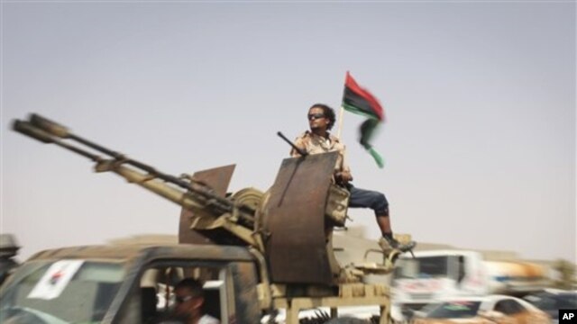 Rebels reinforcements from Tripoli goes through a checkpoint between Tarhouna and Bani Walid, towards the front in Bani Walid, Libya, Monday, Sept. 5, 2011.