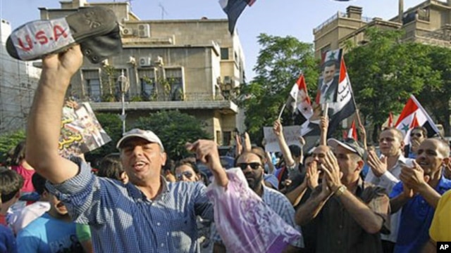 Pro-Syrian President Bashar Assad protesters shout slogans as they protest against the visit of the U.S. Ambassador to Syria Robert Ford to the Syrian city of Hama, in front the U.S. embassy in Damascus, Syria, July 8, 2011. Hundreds of thousands of Syria