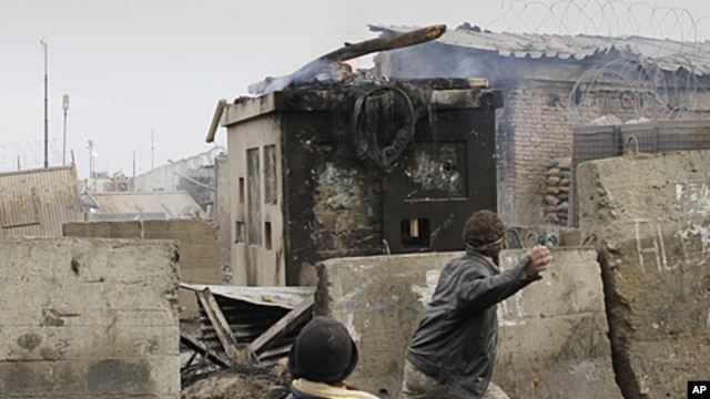Afghans throw stones towards US soldiers in front of the US base in Bagram, during an anti US demonstration, February 21, 2012.