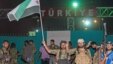 FILE - Fighters from the Kurdish People's Protection Units and Free Syrian Army's Al-Tahrir Brigade gesture while posing on the Syrian-Turkish border Tel Abyad of Raqqa governorate after they said they took control of the area, June 15, 2015.