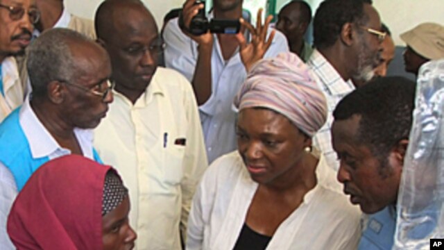 Valerie Amos, center in white coat, United Nations Under-Secretary-General for Humanitarian Affairs and Emergency Relief Coordinator talks to a Somali mother from southern Somalia at Banadir hospital in Mogadishu, Somalia, August 13, 2011