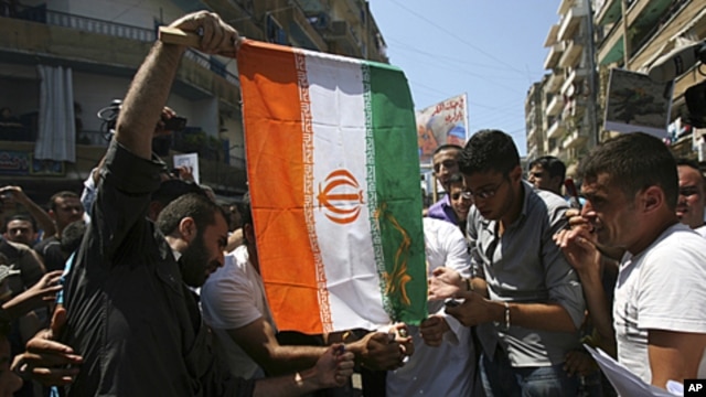 Protesters burn an Iranian flag during a protest organized by Lebanese and Syrians living in Lebanon, to express solidarity with Syria's anti-government protesters, as they march in Tripoli, northern Lebanon. The protesters are opposed to Iran, which has 