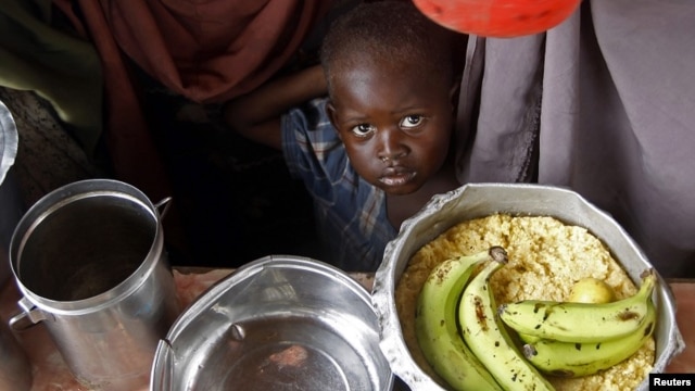 A boy waits for food during a food distribution from an international Non-government Organization (NGO) in Mogadishu June 30, 2012