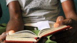 Recovering heroin addict reads his Narcotics Anonymous book at Defence Drugs Women Organisation, Mombasa, Kenya, July 20, 2012. (Jill Craig/VOA)