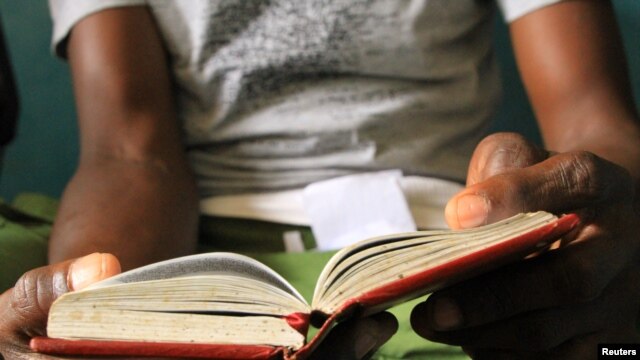 Recovering heroin addict reads his Narcotics Anonymous book at Defence Drugs Women Organisation, Mombasa, Kenya, July 20, 2012. (Jill Craig/VOA)