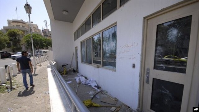 A man checks the damaged U.S. embassy after pro-government protesters attacked the embassy compound in Damascus, Syria, July 11, 2011