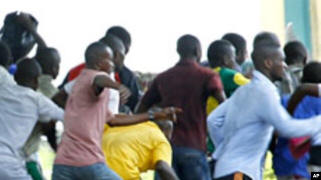 Supporters of Congolese opposition leader Etienne Tshisekedi run as riot police charge with tear gas and live fire outside their candidate's headquarters in Kinshasa, Democratic Republic of Congo, December 8, 2011