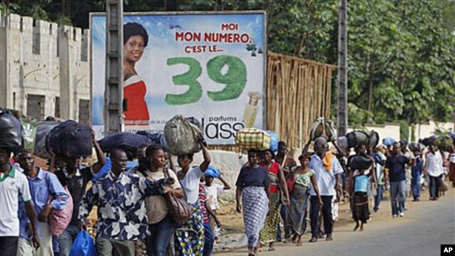 Residents of the Abobo district carry their belongings as they flee the neighborhood which has become a hub for street violence in the nation's ongoing political standoff, in Abidjan, Ivory Coast, February 28, 2011