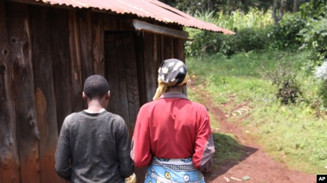 A mother walks beside her mentally disabled 14-year-old daughter who was raped by a neighbor in Kabazi, Kenya, August 24, 2010.