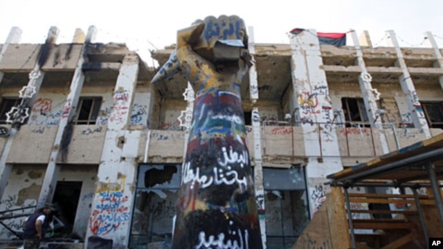 Rebel fighters walk inside Bab Al Azaziya compound in Tripoli August 26, 2011