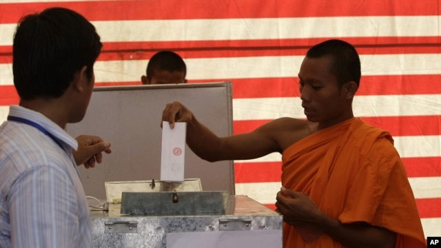 Cambodian Buddhist monk, right, casts his ballot in local elections at Wat Than pagoda's polling station in Phnom Penh, file photo. 
