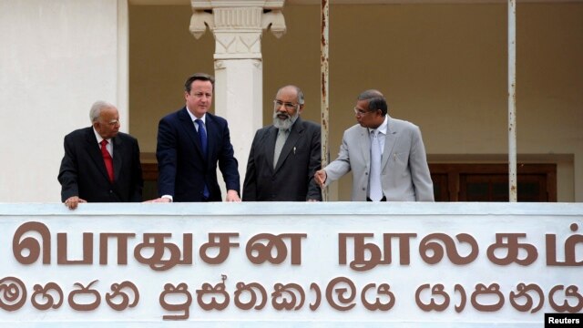 Britain's PM David Cameron (2nd L), Chief Minister of Northern province, C. V. Vigneswaran (2nd R) and Sri Lankan Tamil National Alliance (TNA) party leader R. Sampanthan (L) look out from the public library in Jaffna, north of Colombo, Nov. 15, 2013. 