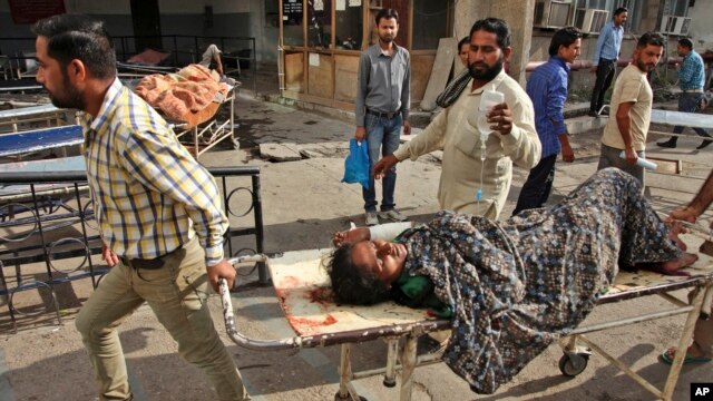 Uma mulher indiana é levada a um hospital governamental de faculdade de medicina depois de ter sido ferido em disparo por soldados paquistaneses do outro lado da fronteira entre Índia e Paquistão em Jora fazenda em Ranbir Singh Pura, em Jammu, Índia, 08 de outubro de 2014.