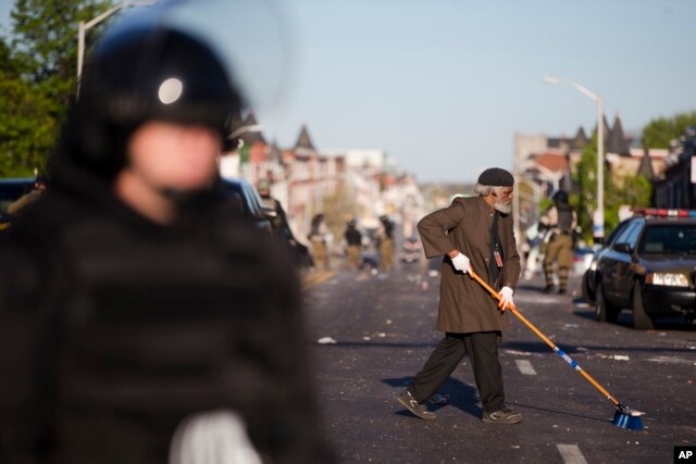 Một cư dân Baltimore quét dọn đường phố sau các vụ bạo loạn.