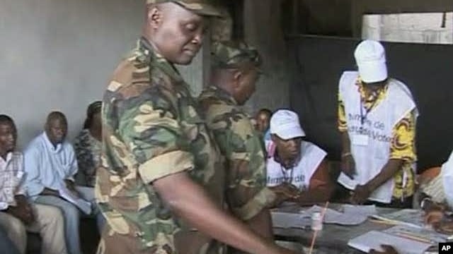 A member of Guinea's military casts a ballot during Guinea's first round of presidential elections