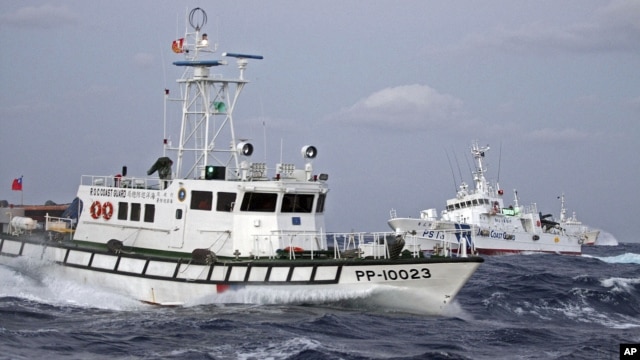In this photo released by Taiwan's Central News Agency, a Taiwan Coast Guard patrol boat, front, comes in close proximity with a Japan Coast Guard patrol boat near the disputed islands called Senkaku in Japan and Diaoyu in China, in the East China Sea, Se
