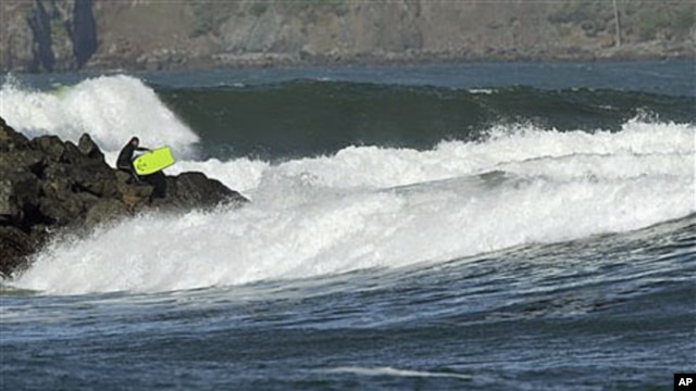 With a tsunami warning in effect for Northern California, a surfer enters the water at Fort Point near the Golden Gate Bridge in San Francisco, California, March 11, 2011