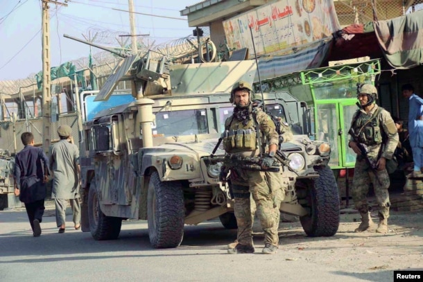 Afghan security forces keep watch in front of their armored vehicle in Kunduz city, Afghanistan, Oct. 4, 2016.