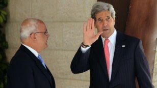 US Secretary of State John Kerry (R) waves to the media as he stands next to Palestinian Chief of Negotiator Saeb Erekat upon his arrival for a meeting with Palestinian president Mahmoud Abbas in the West Bank city of Ramallah on May 23, 2013.
