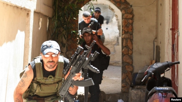 Sunni Muslim gunmen run to take up position in the neighborhood of Bab al-Tebbaneh in Tripoli, northern Lebanon, during sectarian clashes between Sunni Muslims and Alawites, August 24, 2012. 