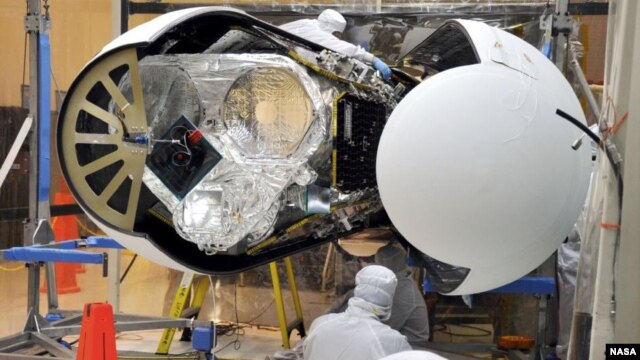 An Orbital Sciences technician completes final checks of NASA's Nuclear Spectroscopic Telescope Array, or NuSTAR
