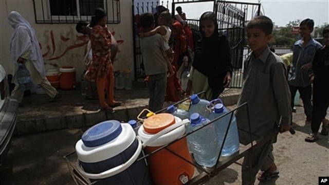 Pakistani boy carries clean water supplies from tanker, Karachi, July 2011 (file photo).