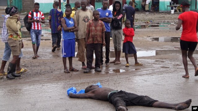 Người dân tụ tập quanh một người đàn ông bị nghi tử vong vì Ebola ở Monrovia, Liberia.