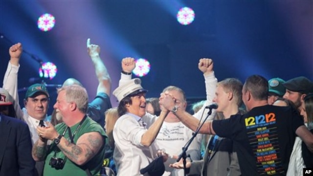 Paul McCartney trên sân khấu cùng các nhân viên cứu hỏa tại Madison Square Garden, New York.