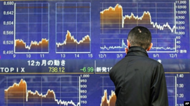 A man looks at a stock quotation board outside a brokerage in Tokyo, December 12, 2011.