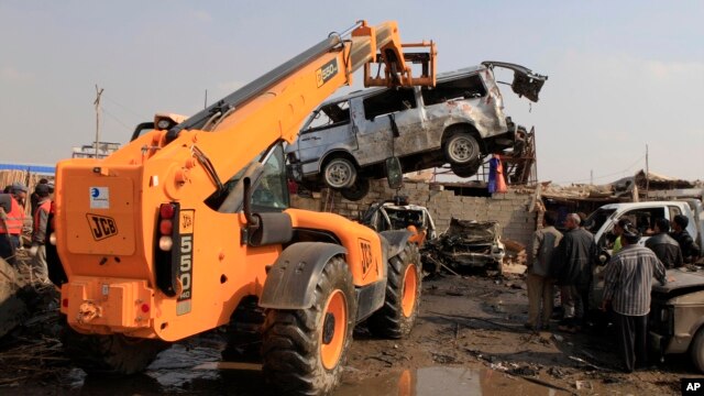 People inspect the scene of a car bomb attack in Baghdad's northern Kazimyah neighborhood, February 8, 2013. 