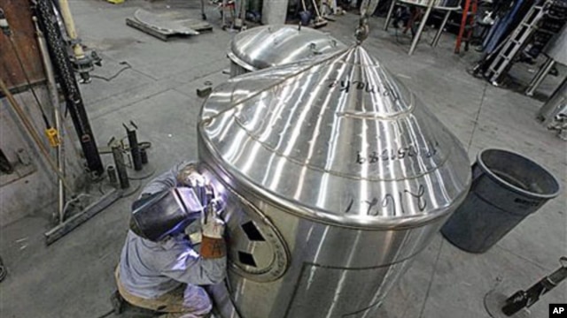 A workman welds a tank at JV Northwest, which manufactures stainless steel vessels, in Camby, Oregon, February 13, 2012.