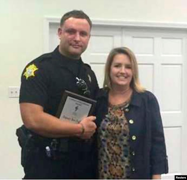 Richland County Sheriff's Department Officer Senior Deputy Ben Fields, left, is pictured with Lonnie B. Nelson Elementary School Principal Karen Beaman after receiving Culture of Excellence Award, in Columbia, S.C., Nov. 12, 2014.