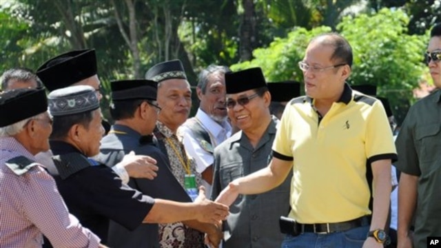 Presiden Filipina Benigno Aquino III (kanan) disambut oleh para anggota Front Pembebasan Islam Moro (MILF) dalam kunjungannya ke Camp Darapanan, wilayah Sultan Kudarat, propinsi Maguindanao di selatan Filipina, Senin (11/2).
