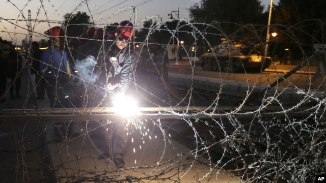 Egyptian Army soldiers install barbed wire outside the presidential palace to secure the site of overnight clashes between supporters and opponents of President Mohammed Morsi in Cairo, Egypt, Thursday, Dec. 6, 2012.