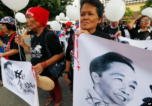 FILE - Supporters of the late Philippine dictator Ferdinand Marcos display his images prior to marching towards the Supreme Court for an overnight vigil, Nov. 7, 2016.