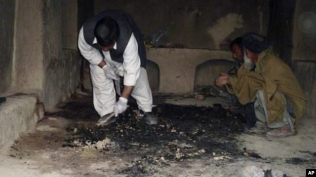 Afghan men investigate at the site of a shooting incident, apparently by a lone U.S. Army sergeant that killed 16 civilians on Sunday, in Kandahar province, March 11, 2012. 