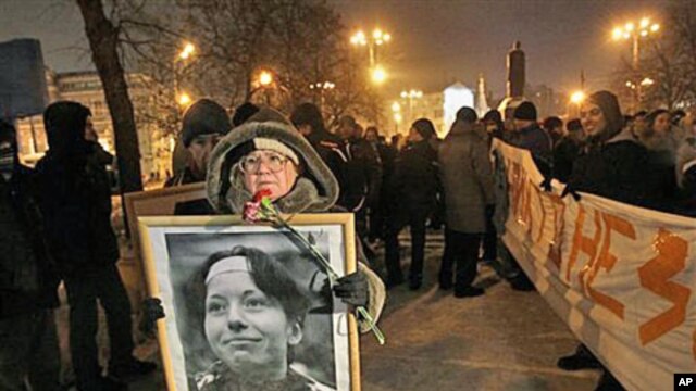 A demonstrator holds a portrait of slain reporter Anastasiya Baburova during a memorial rally in downtown Moscow, held in memory of rights lawyer Stanislav Markelov and Baburova, who were shot in broad daylight on a street near the Kremlin two years ago, 