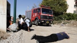 Israelis take cover as a siren warning of an incoming rocket sounds in Kiryat Malachi, southern Israel, Thursday, November 15, 2012.