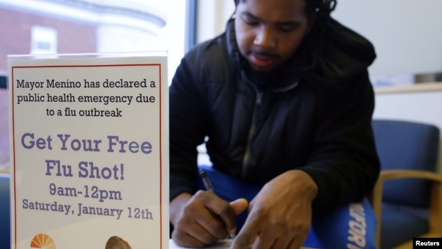 Oddelio Reid fills out paperwork before getting an influenza vaccine injection during a flu shot clinic at Dorchester House, a health care clinic, in Boston, Massachusetts January 12, 2013.