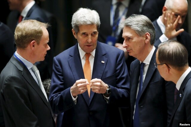 FILE - From left, British Ambassador to the U.N. Matthew Rycroft, U.S. Secretary of State John Kerry, Britain's Foreign Secretary Philip Hammond, U.N. Secretary General Ban Ki-moon speak before a meeting of the U.N. Security Council in New York, Dec. 18, 2015.