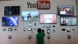 FILE - A man looks at a device at the YouTube booth at Google I/O 2013 in San Francisco.