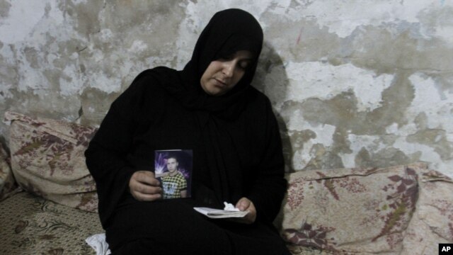 Palestinian Nadia Abu Nada holds a picture of her son Ihab Abu Nada, who set himself on fire because he could not find a job, in Gaza City, September 3, 2012.  