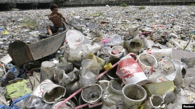 A boy collects plastic from a garbage-covered river in Manila March 21, 2010. 