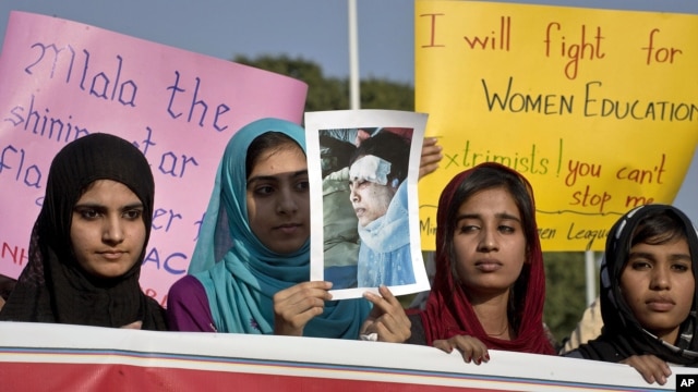Women supporters of a Pakistani religious group 'Minhaj-ul-Quran' hold a poster of schoolgirl Malala Yousufzai, 14, who was shot on Tuesday by the Taliban, during a demonstration in Islamabad, Pakistan, Oct. 13, 2012.