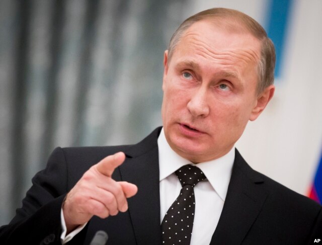 Russian President Vladimir Putin gestures while speaking to the media during his and France's President Francois Hollande news conference following the talks in Moscow, Russia, Nov. 26, 2015.