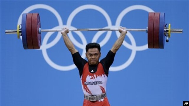 Eko Yuli Irawan saat melakukan angkatan dalam nomor 62 kilogram angkat besi putera di Olimpiade London (30/7). 