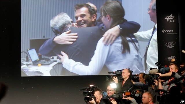 Scientists celebrate at the European Space Agency after the first unmanned spacecraft Philae landed on a comet called 67P/Churyumov-Gerasimenko on Nov. 12, 2014.  (AP Photo/Michael Probst)