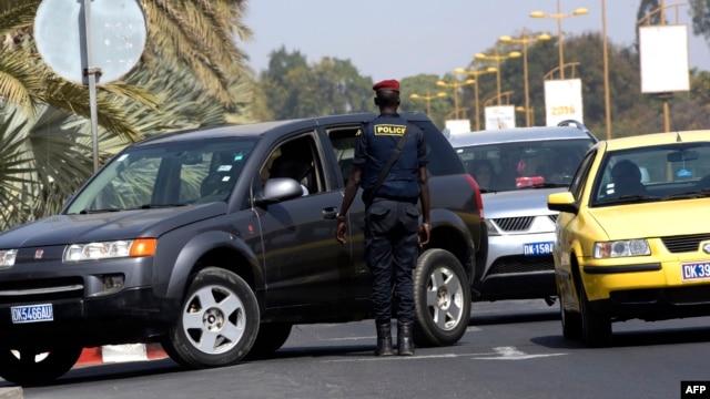 A Senegalese police officer conducts a vehicle inspection at the entrance of a Dakar hotel, Jan. 22, 2016. Security measures have been reinforced close to public buildings, following jihadist attacks in Bamako and Ouagadougou.