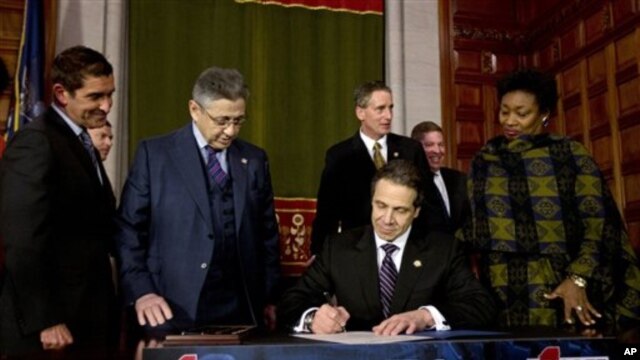 Gubernur New York, Andrew Cuomo, menandatangani "NY Safe Act" di Albany, New York, 15 Januari 2013. (AP Photo/Mike Groll). New York menjadi negara bagian pertama di Amerika yang memberlakukan aturan untuk memperketat penggunaan senjata api.