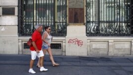 Tourists walk past Spain's former Banco Espanol de Credito in Madrid, August 28, 2012. 